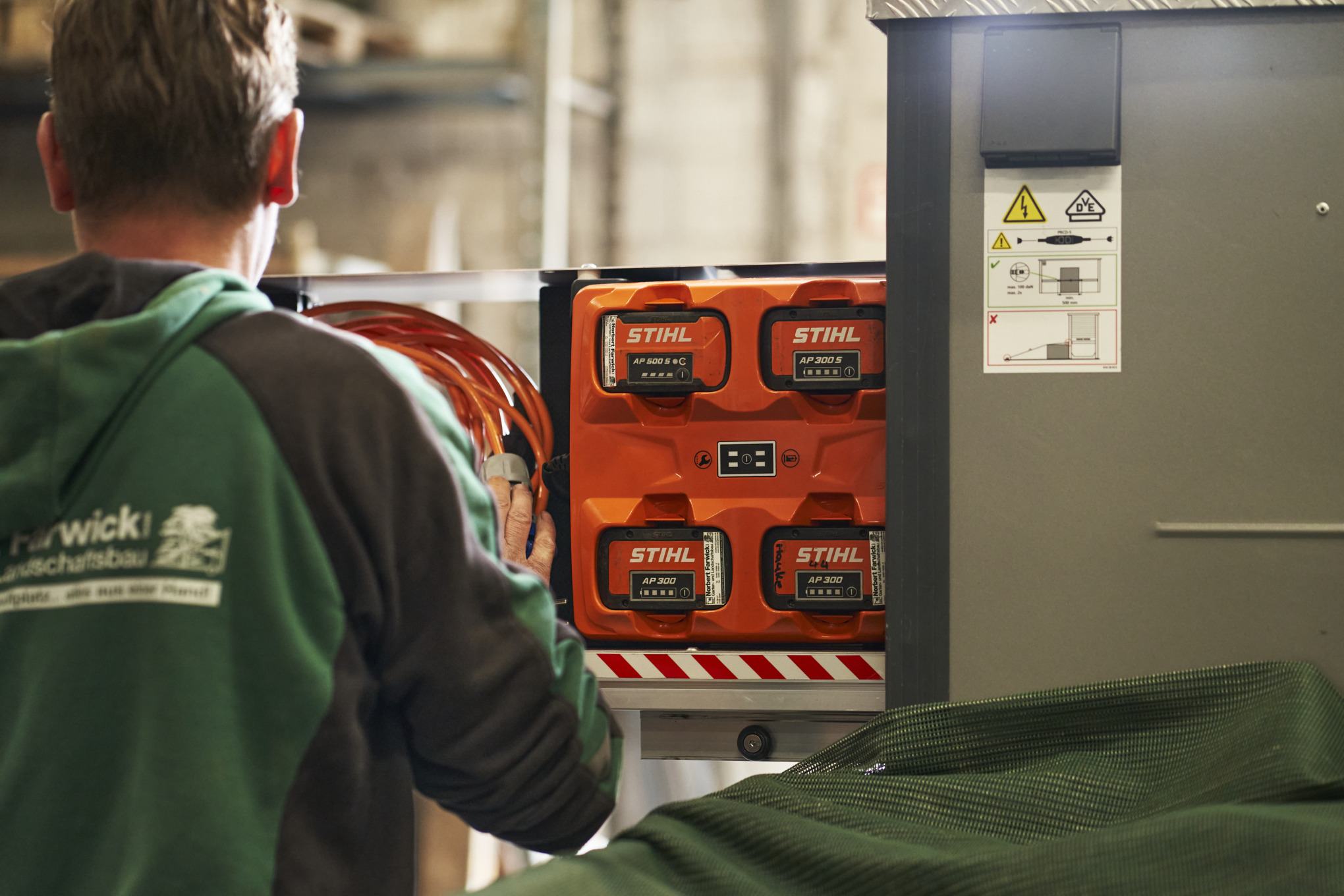 Een medewerker van Farwick GmbH in achteraanzicht staat voor een bottTainer powered by STIHL