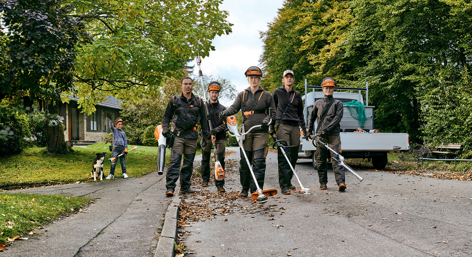 A gardening and landscaping team with STIHL professional cordless tools walks down a street.
