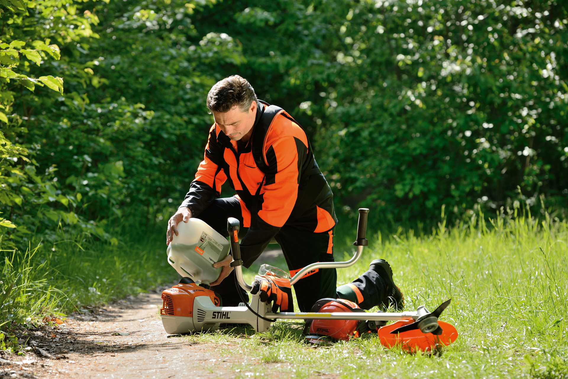 Een man vult een STIHL bosmaaier met een benzine-oliemengsel.