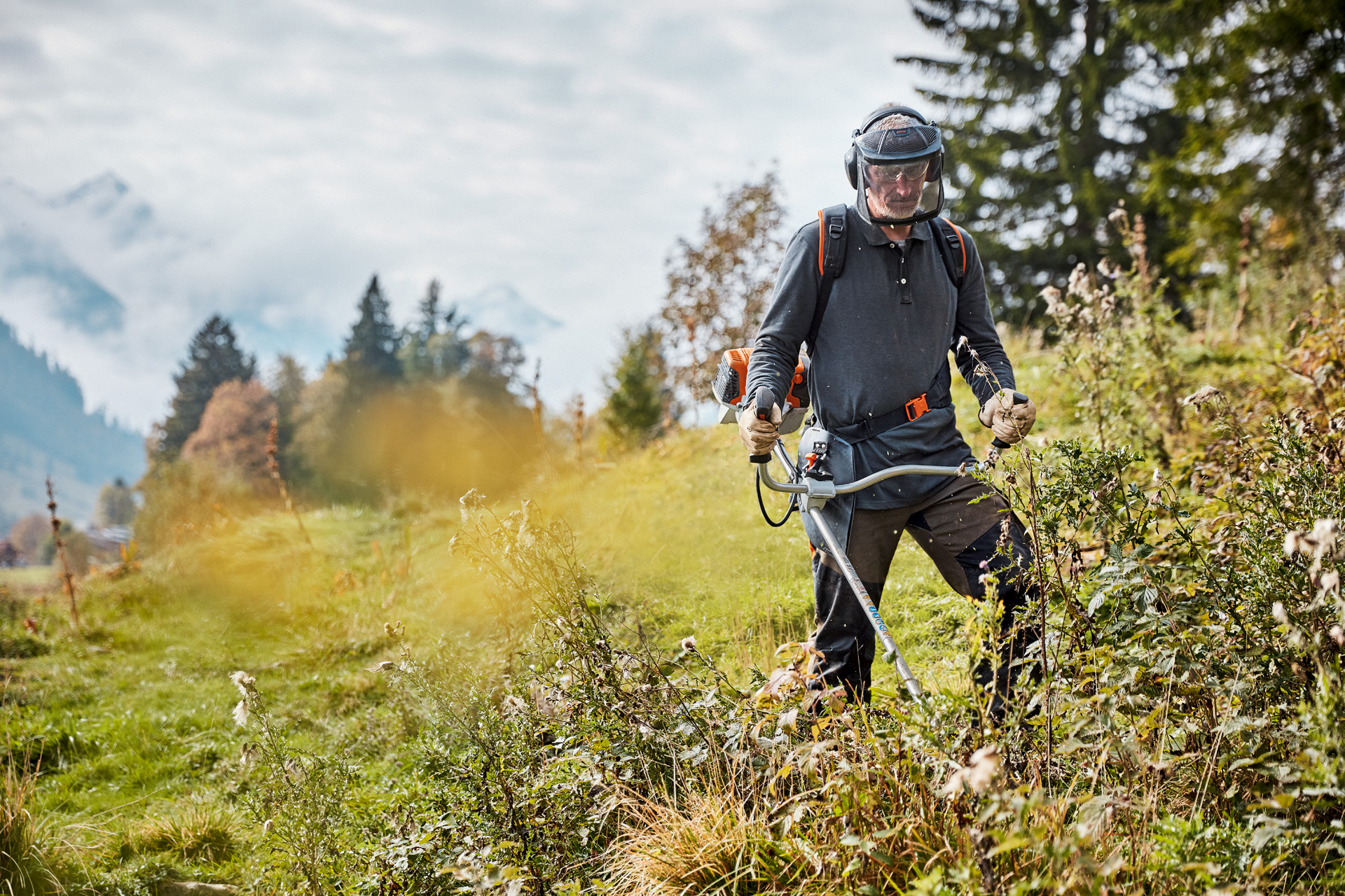 Een man werkt met een STIHL FS 131 in een groot weiland.