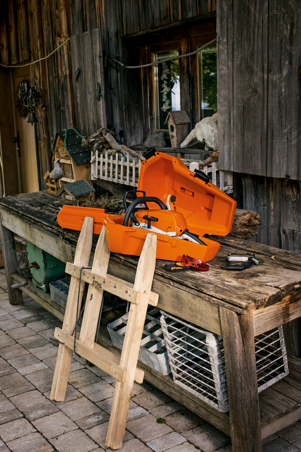 STIHL opbergkoffer voor kettingzagen naast accessoires op een houten werkbank