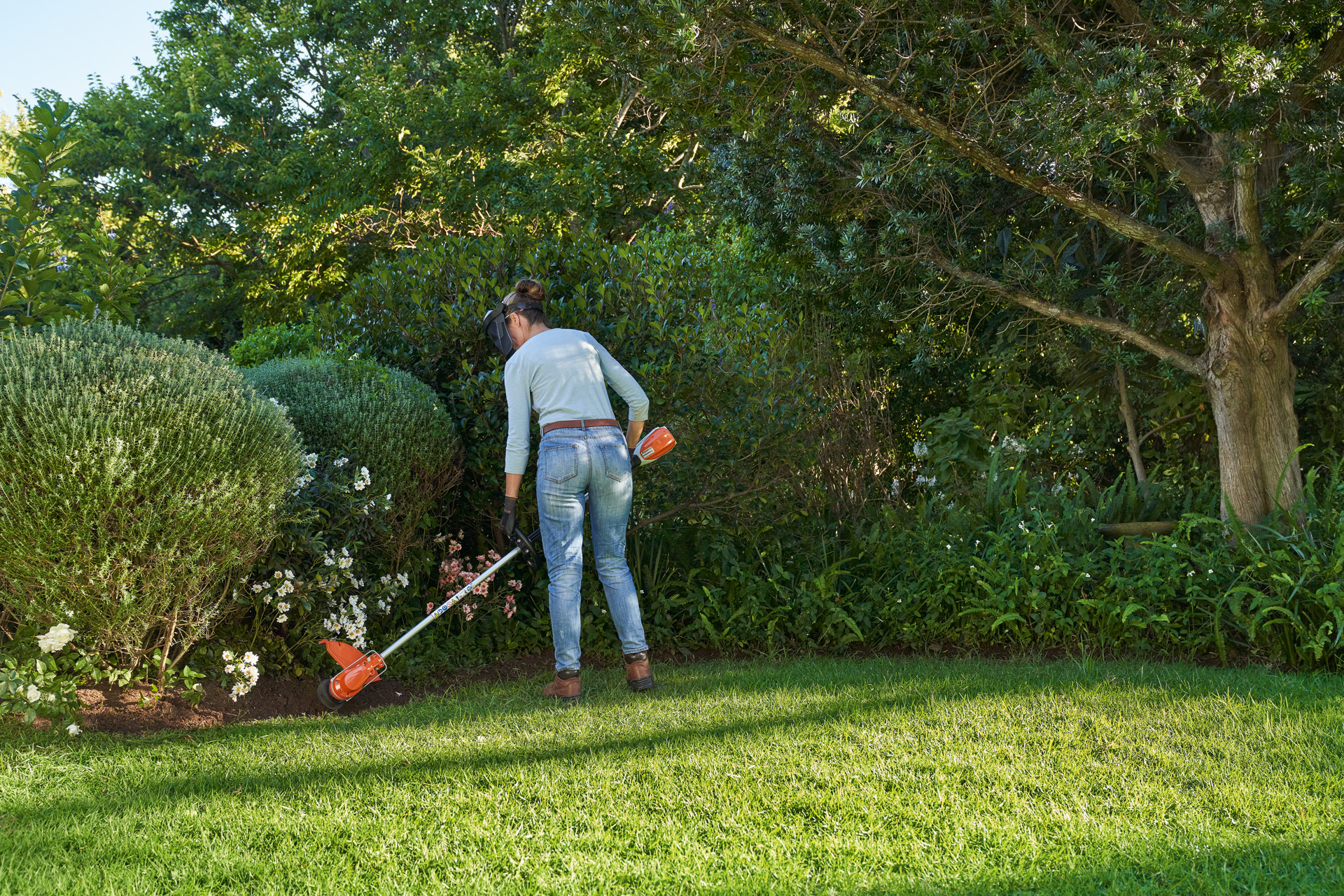 Vrouw onderhoudt Engelse gazonrand met een STIHL FSA 60 accukantenmaaier 