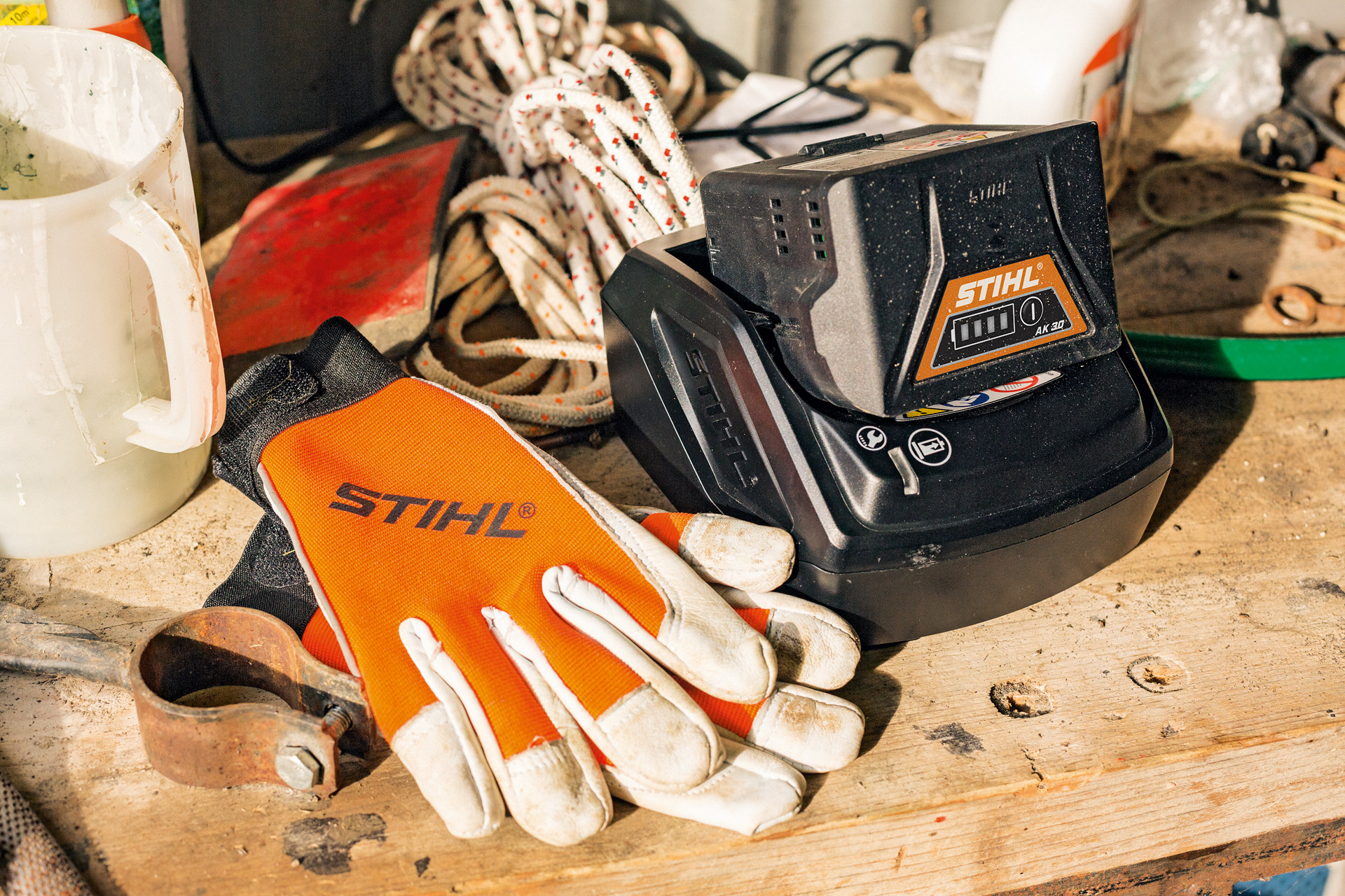 Une batterie Lithium-ion STIHL de la gamme AK en cours de charge avec des gants