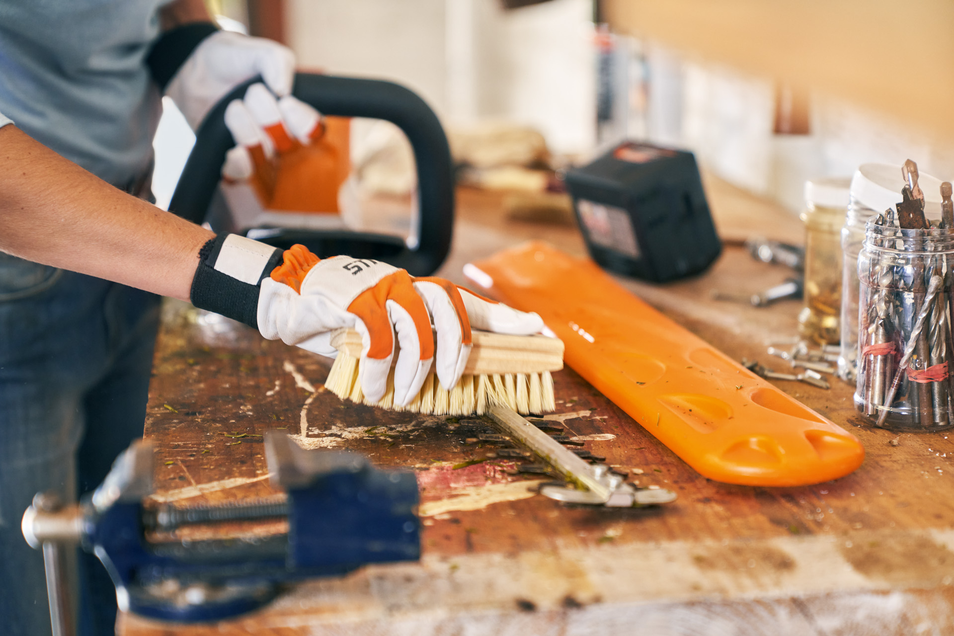 Onderhoud van een tuinmachine: STIHL accuheggenschaar HSA 56 wordt met een borstel gereinigd