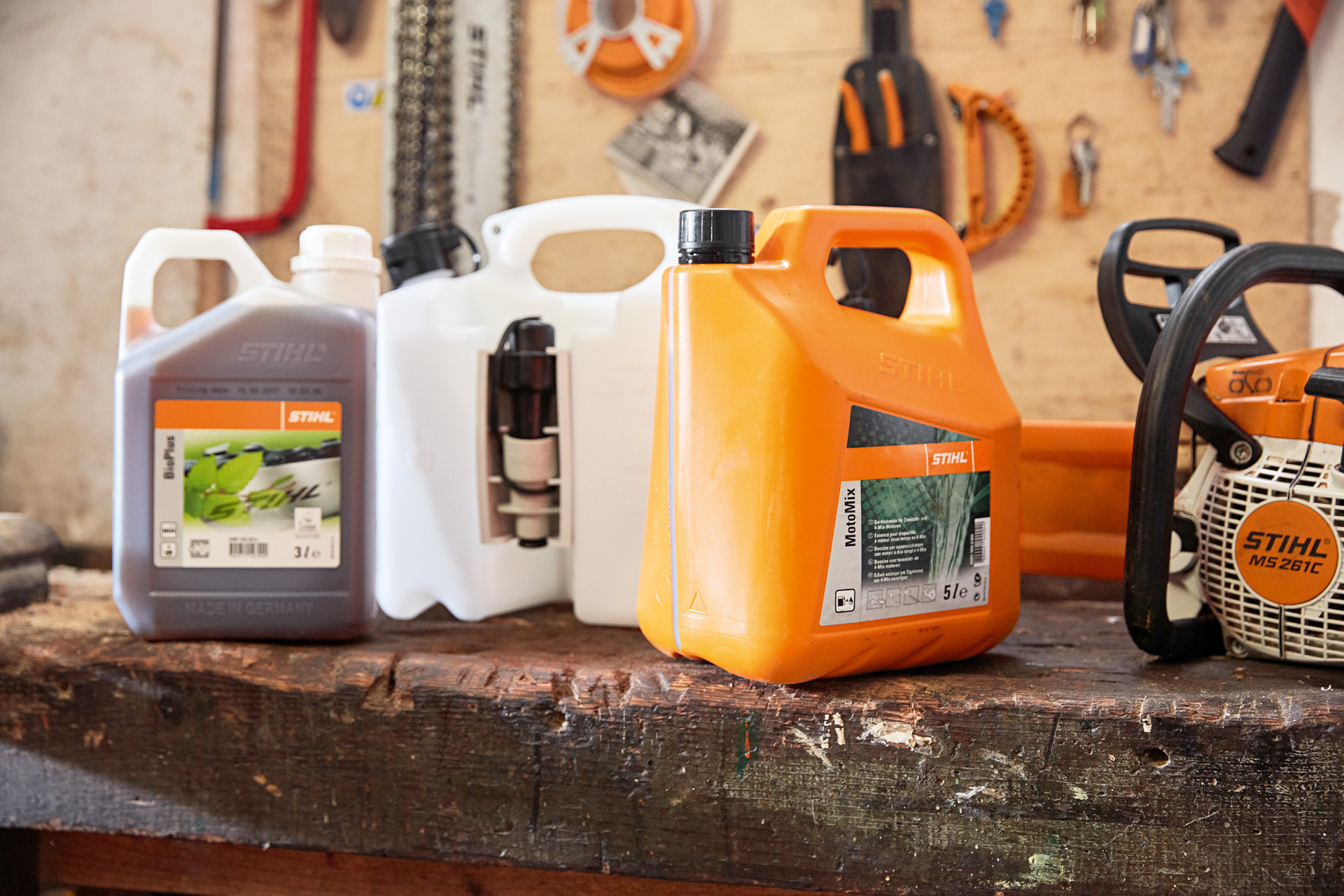 Jerrycan met STIHL MotoMix brandstof voor kettingzagen; olie en benzine en een STIHL MS 261 C in een werkplaats