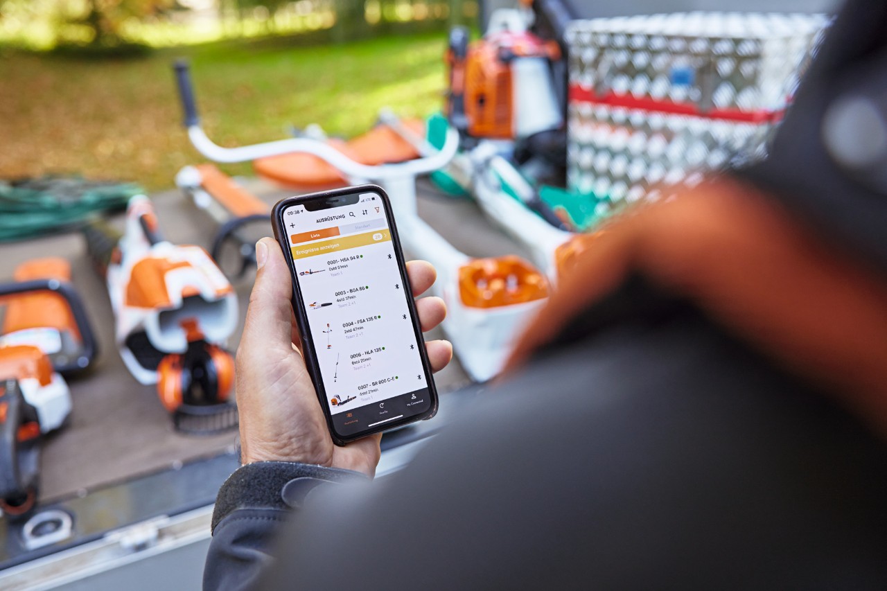 Surface de chargement d’un véhicule à plateau et un smartphone sur lequel la STIHL&nbsp;connected&nbsp;App est ouverte