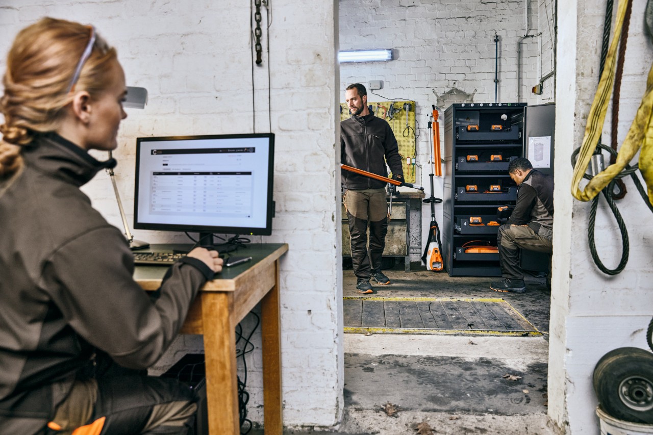 Professionelle Landschaftsgärtner in ihrer Werkstatt, Frau sitzt vor dem angeschlossenen STIHL Portal.