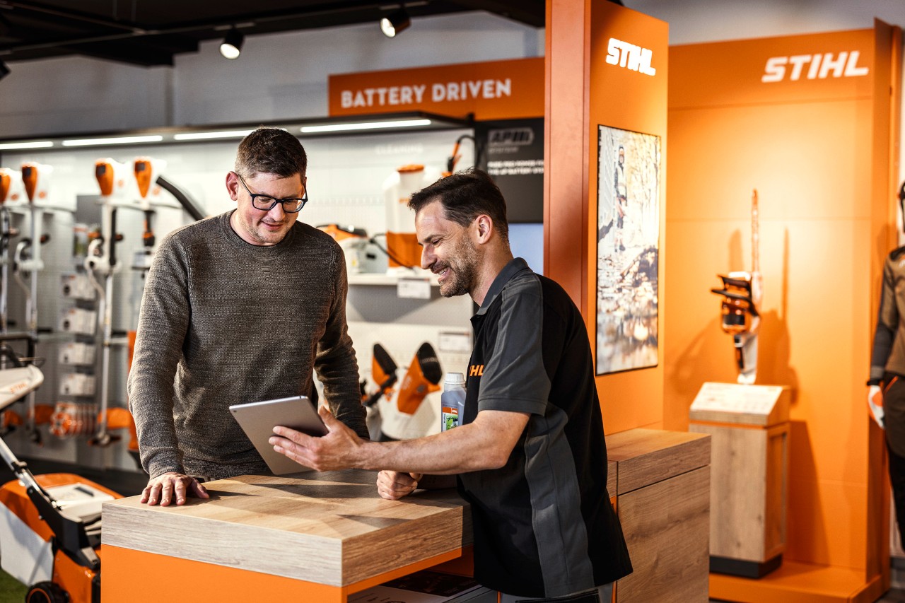 Un distributeur STIHL conseille un client dans une salle d'exposition