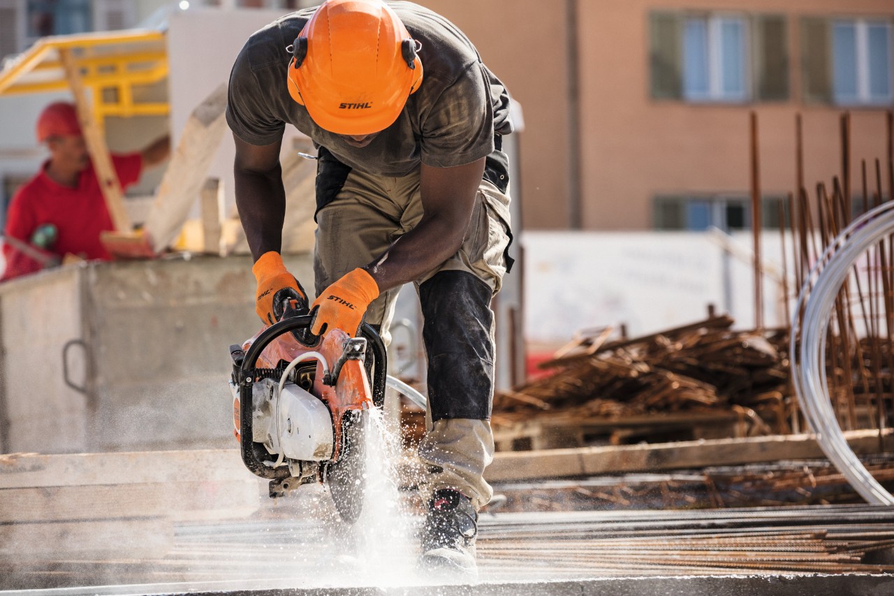 Iemand in veiligheidsuitrusting aan het werk met een doorslijper