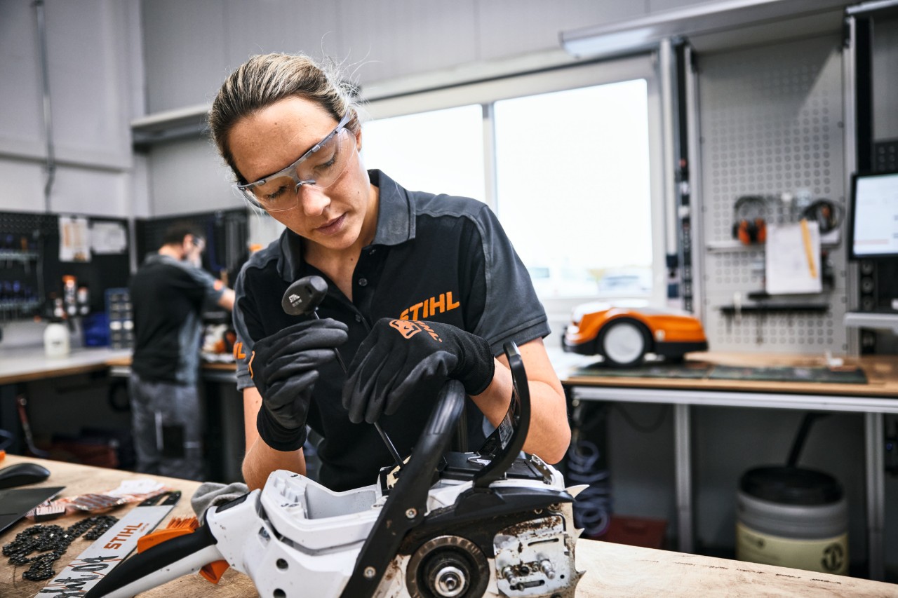 Een STIHL medewerker of een vakman repareert een motorzaag