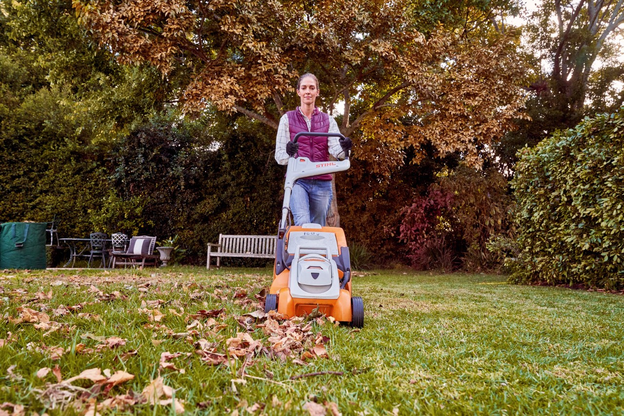 Vrouw gebruikt accugrasmaaier RMA 339 C voor de verzorging van een tuingazon in de herfst 